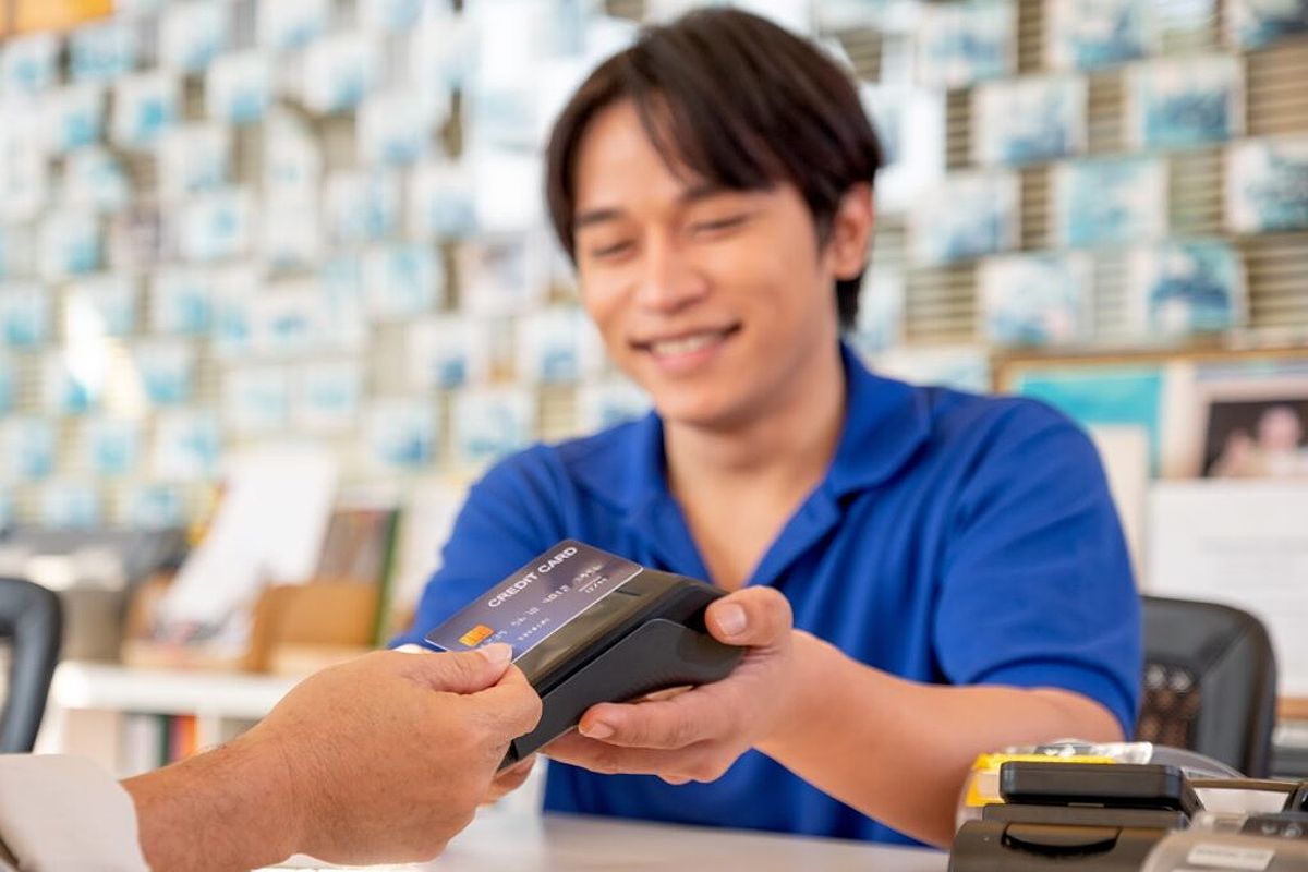 A smiling business owner take a contactless credit card payment