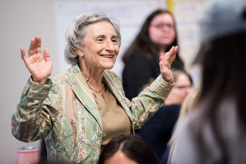 Older female educator engaging with students in a classroom